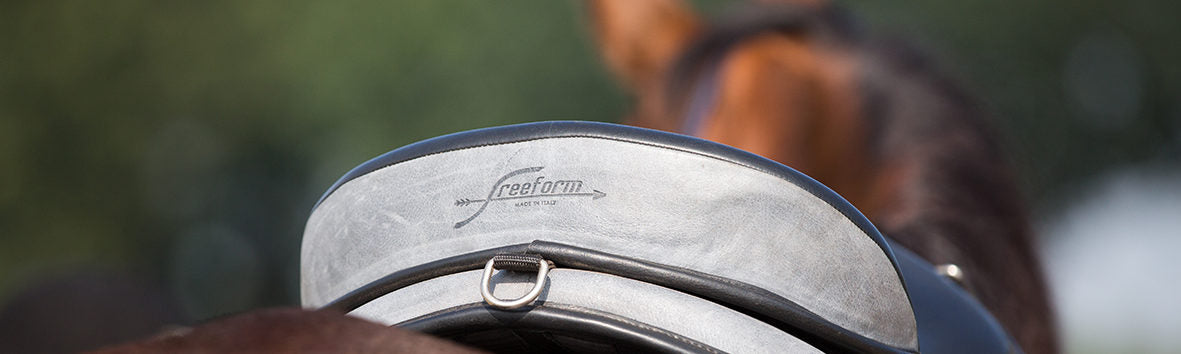 Close up of the Freeform logo on a Freeform Saddle cantle on a bay horse.